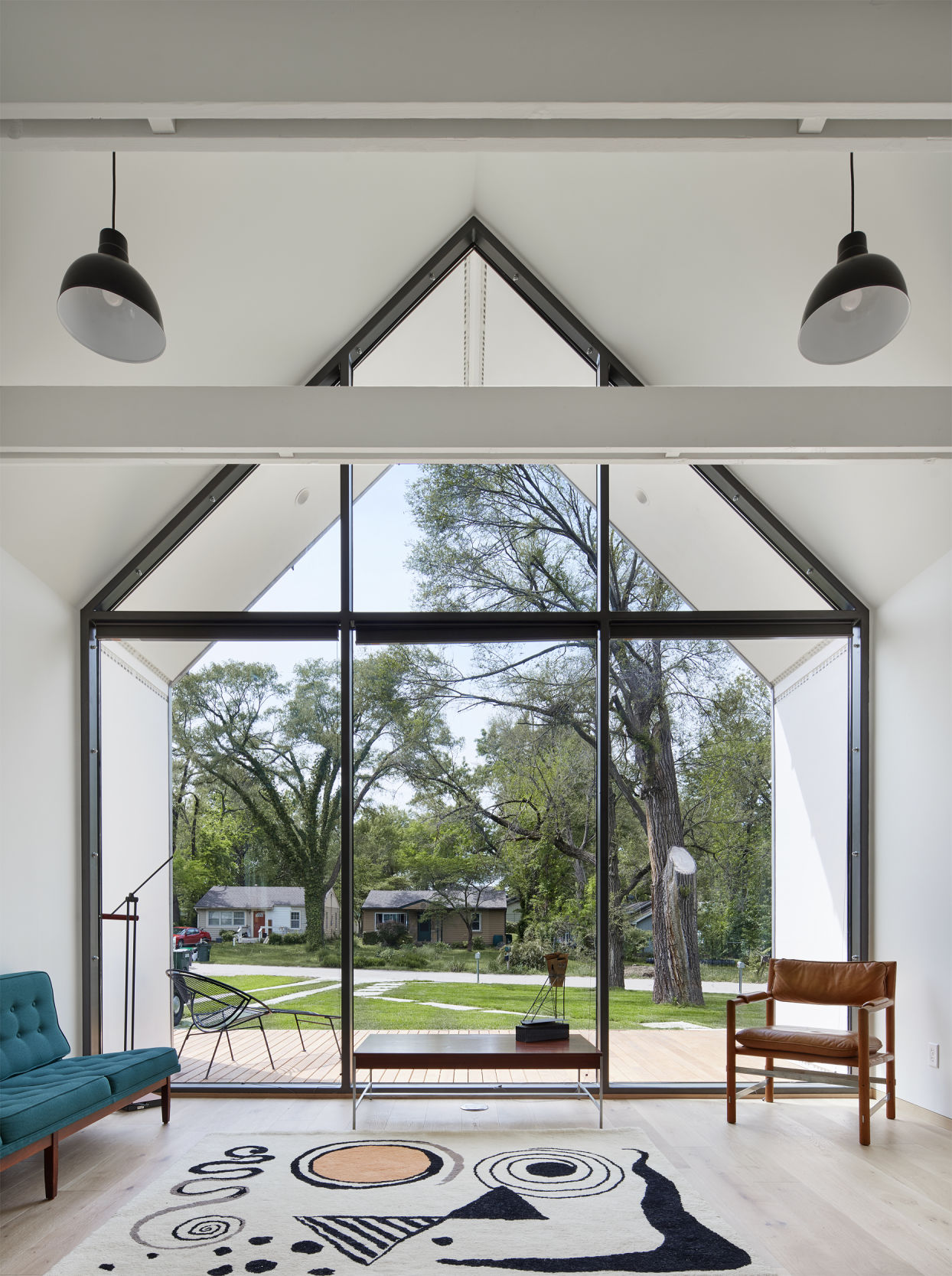 The inside of a house shows a wide window and living room